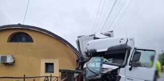 Trei dintr-un foc! Un șofer de TIR a distrus un autoturism, un gard și o anexă gospodărească